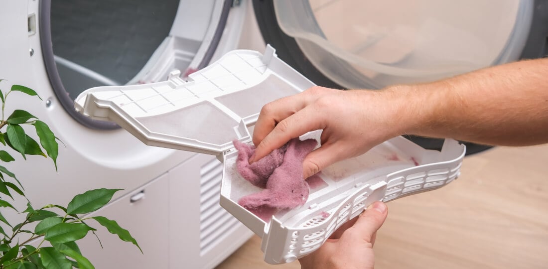 Person's hands removing the lint from a dryer's lint trap