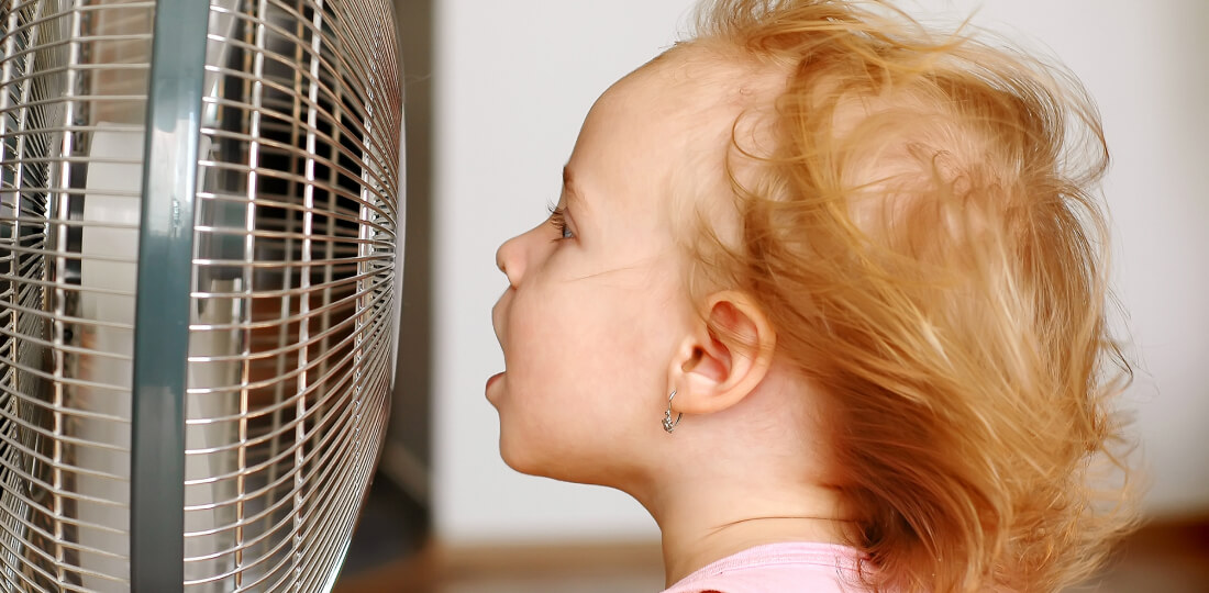Child sitting directly in front of a fan